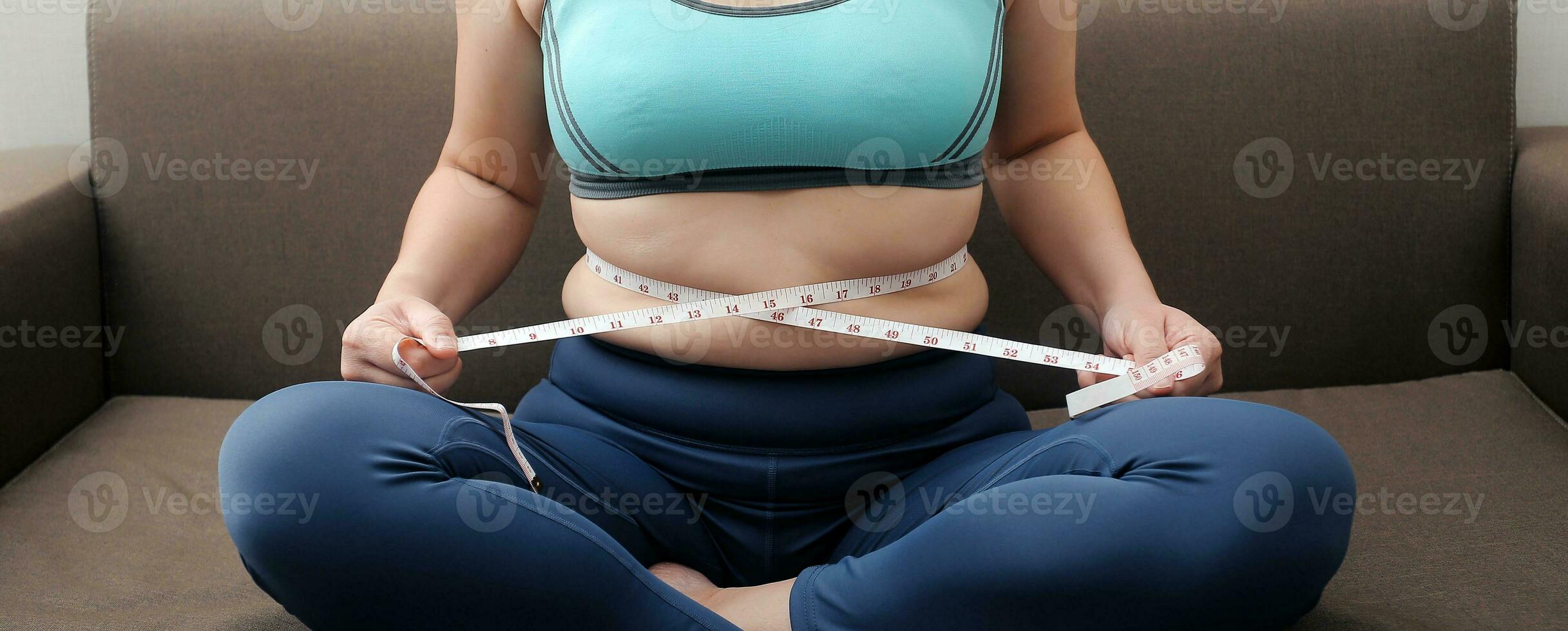 Women body fat belly. Obese woman hand holding excessive belly fat. diet lifestyle concept to reduce belly and shape up healthy stomach muscle. photo