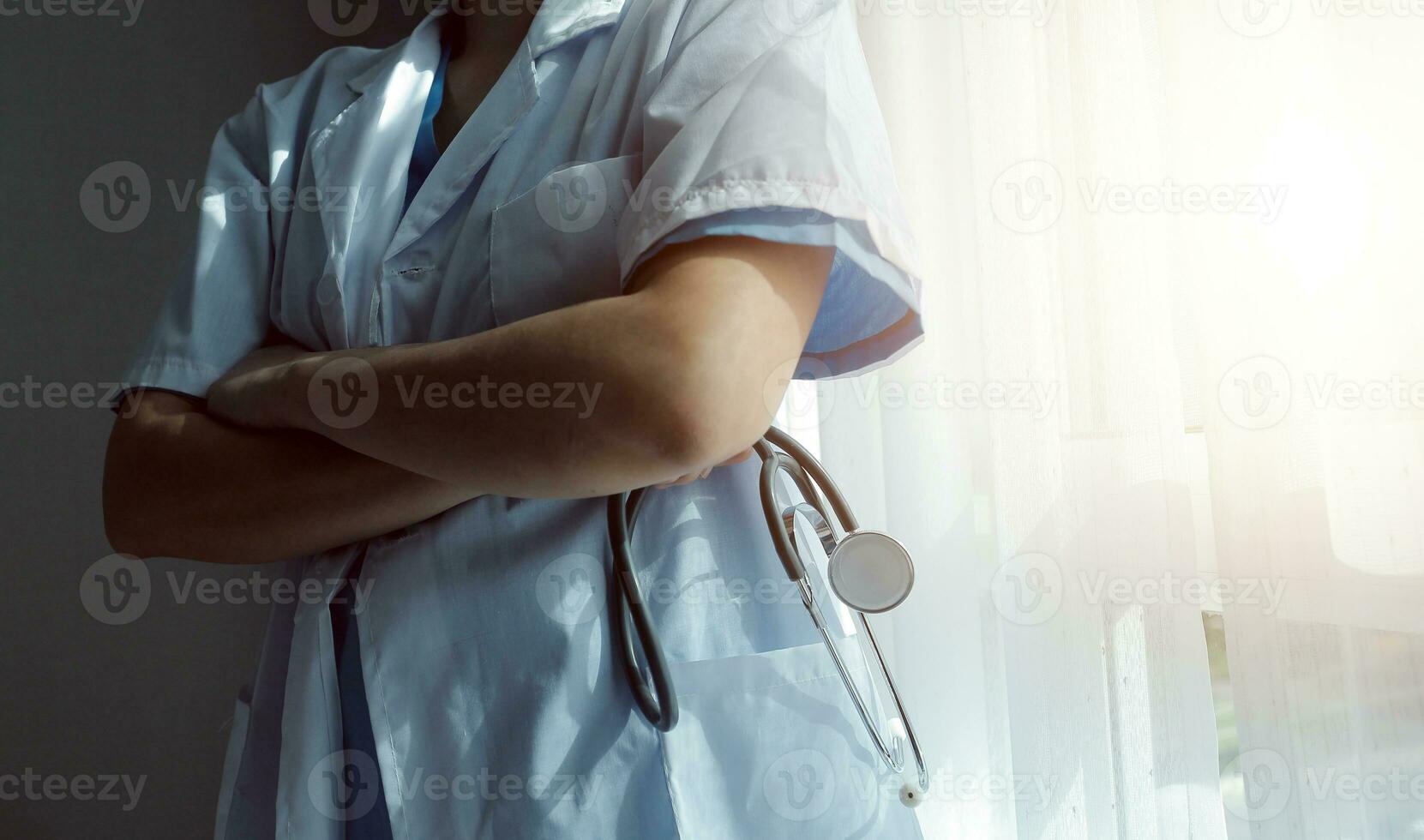 concepto médico y de salud. médico de medicina con estetoscopio en la mano y los pacientes vienen al fondo del hospital. foto