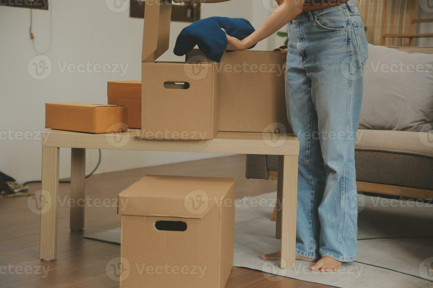 Beautiful young couple in love having fun unpacking things from cardboard boxes while moving in together in their new apartment photo