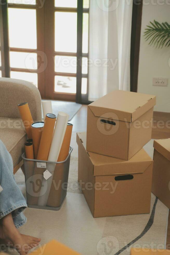 Beautiful young couple in love having fun unpacking things from cardboard boxes while moving in together in their new apartment photo