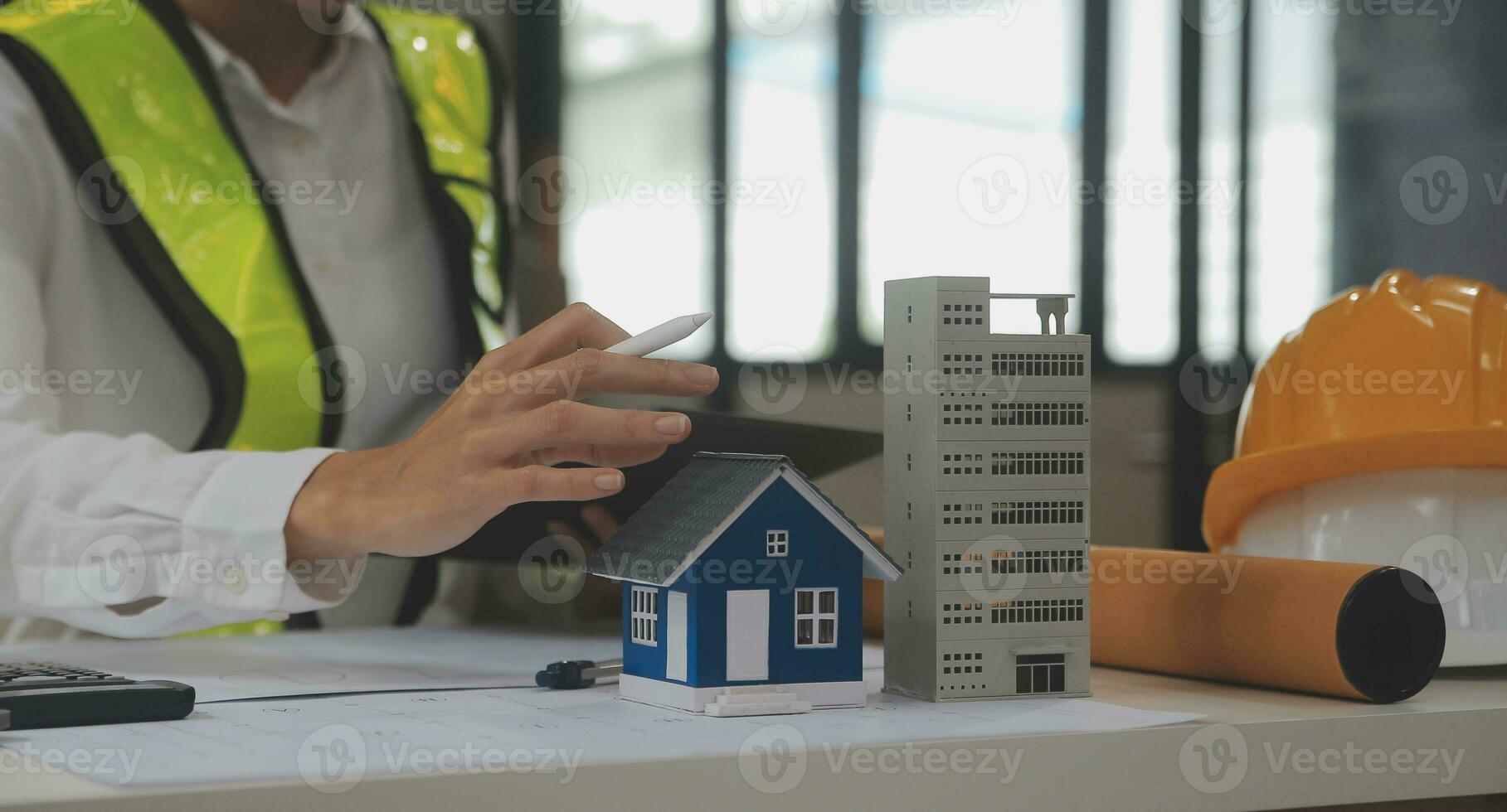 reunión de trabajo en equipo de ingenieros, trabajo de dibujo en la reunión de planos para el trabajo del proyecto con un socio en la construcción de modelos y herramientas de ingeniería en el concepto de sitio de trabajo, construcción y estructura. foto