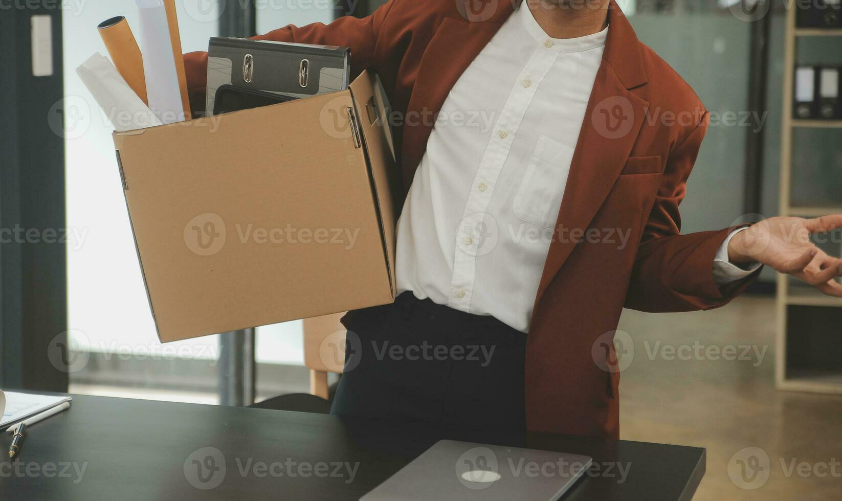 Business man employee stressful resignation from job while picking up personal belongings into brown cardboard box and carrying to walking out from office photo