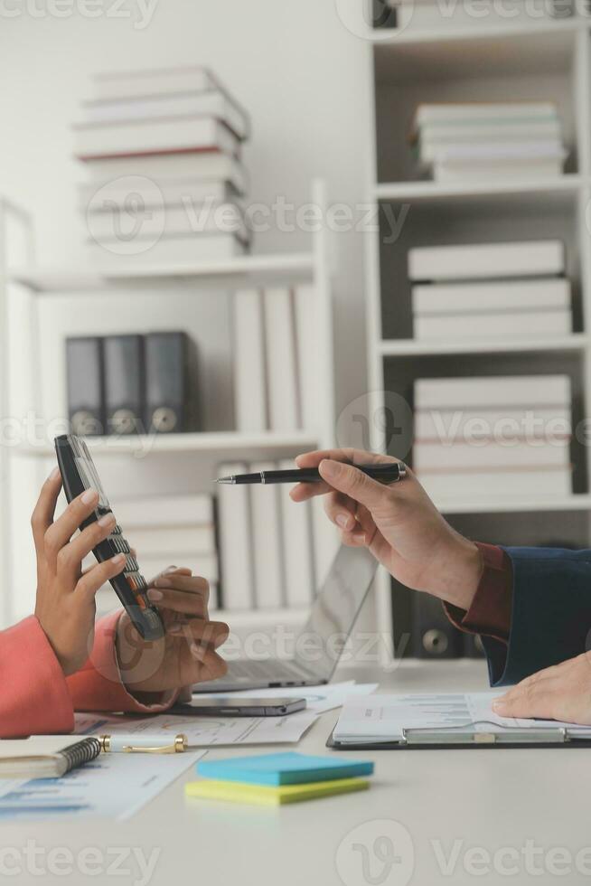 Close up Business woman using calculator and laptop for do math finance on wooden desk, tax, accounting, statistics and analytical research concept photo