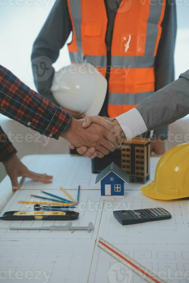Construction and structure concept of Engineer or architect meeting for project working with partner and engineering tools on model building and blueprint in working site, contract for both companies. photo