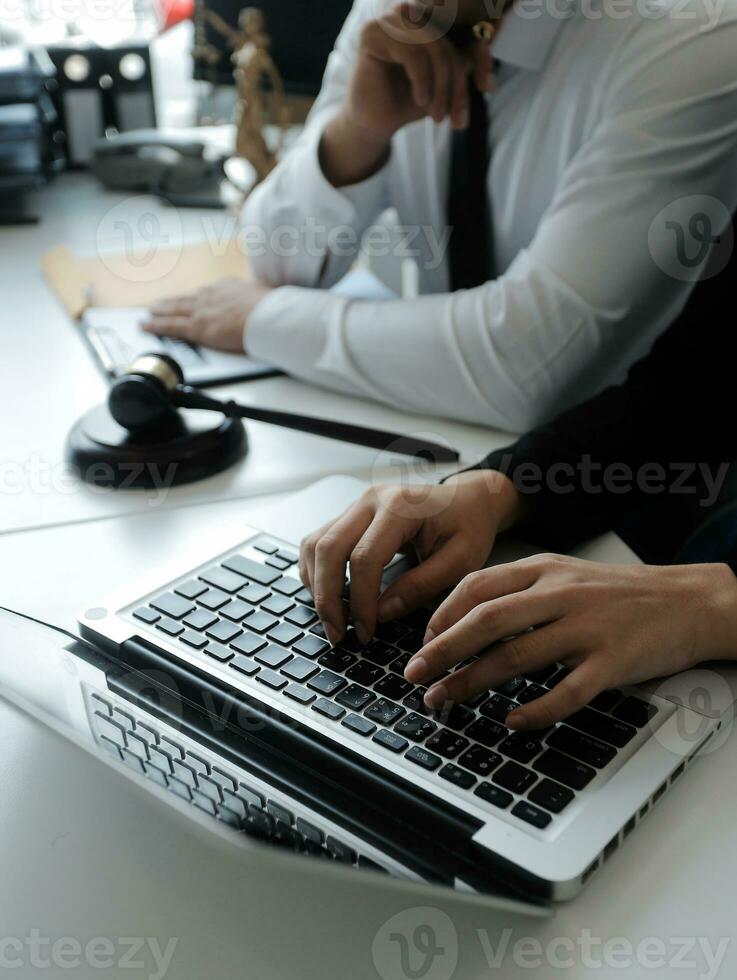 Male lawyer working with contract papers and wooden gavel on tabel in courtroom. justice and law ,attorney, court judge, concept. photo