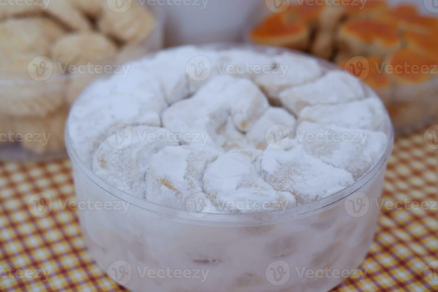 Coconut cookies in a glass bowl on checkered tablecloth photo