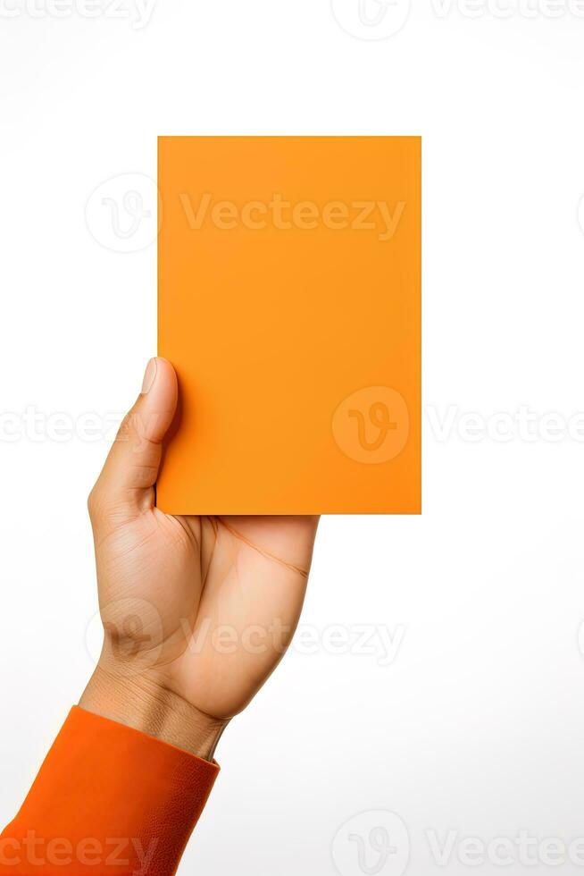 A human hand holding a blank sheet of orange paper or card isolated on a white background. ai generated photo