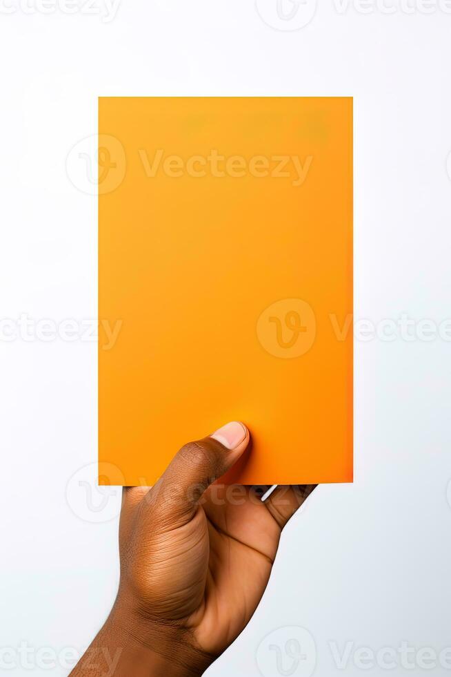 A human hand holding a blank sheet of orange paper or card isolated on a white background. ai generated photo