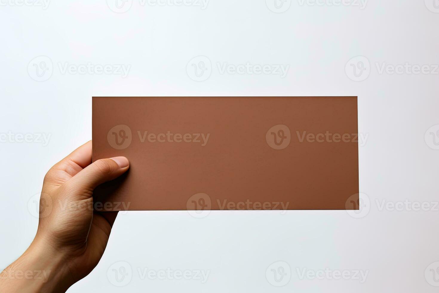 A human hand holding a blank sheet of brown paper or card isolated on a white background. ai generated photo