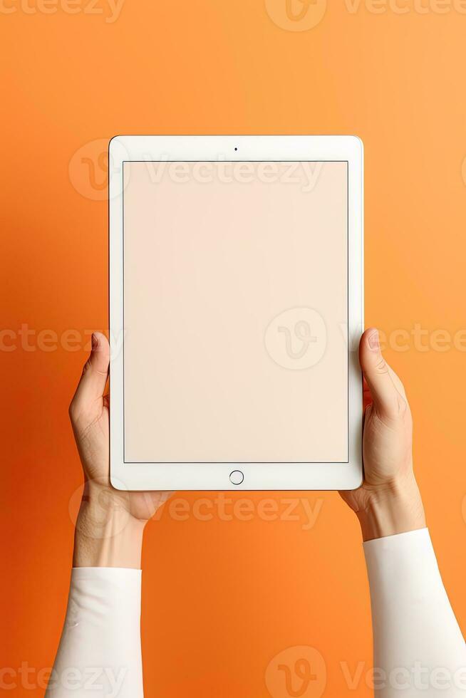 Hand holding tablet with mockup blank screen isolated on orange background. ai generated photo