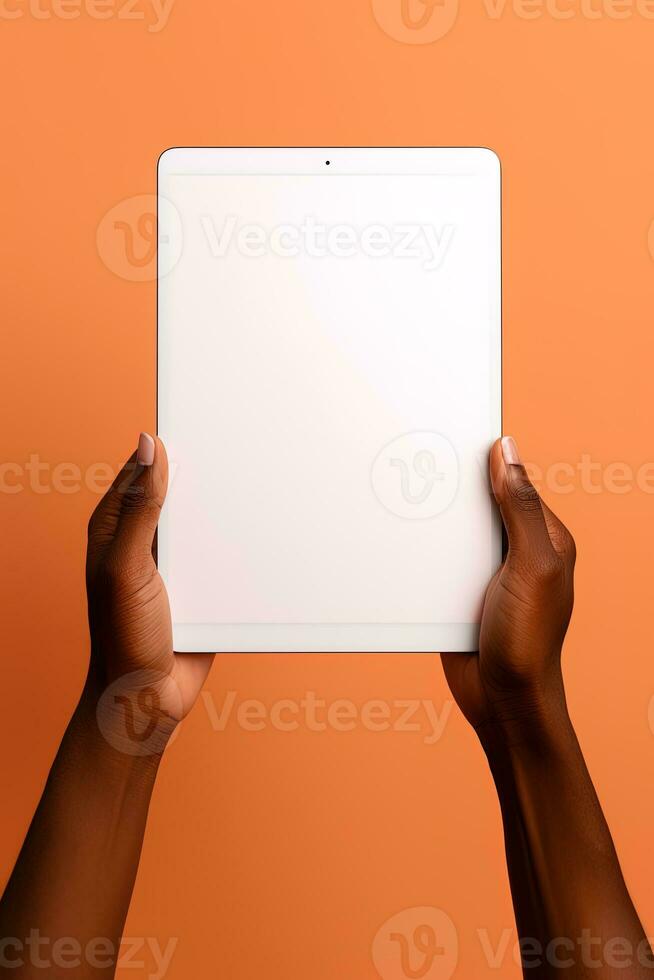 Hand holding tablet with mockup blank screen isolated on orange background. ai generated photo