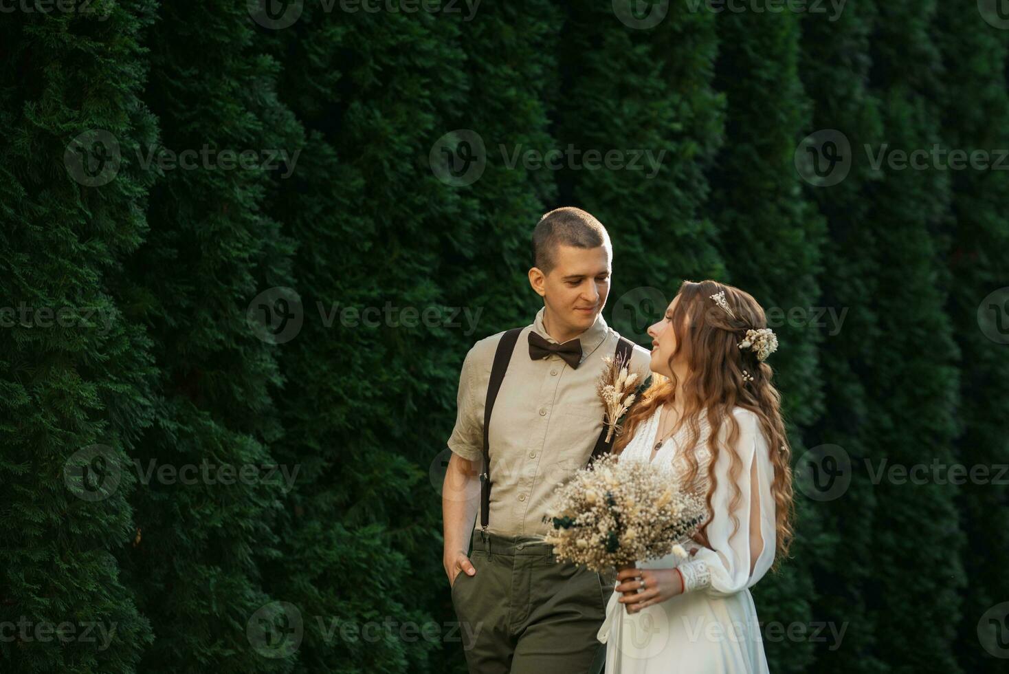 wedding walk of the bride and groom in a coniferous photo