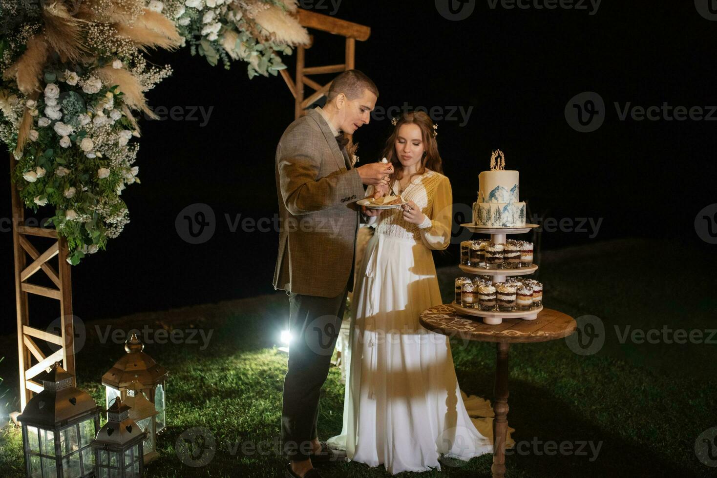 newlyweds happily cut and taste the wedding cake photo