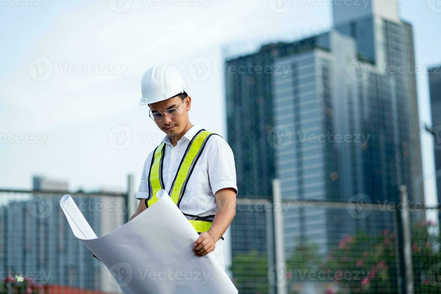 Engineer holding blueprints at construction site. Planning and working on the construction and design of buildings. photo