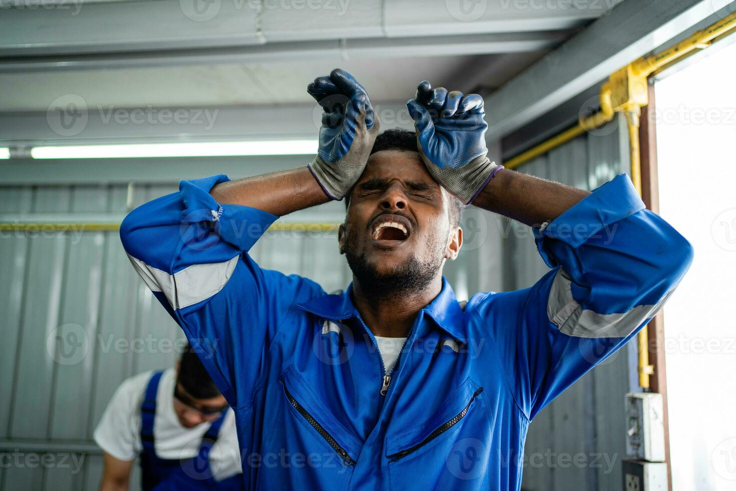 Sick industrial engineer worker touches his forehead with dizziness. work stress Symptoms of factory workers. photo