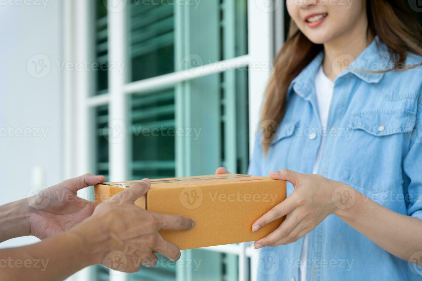 Happy smiling woman receives boxes parcel from courier in front house. Delivery man send deliver express. online shopping, paper containers, takeaway, postman, delivery service, packages photo