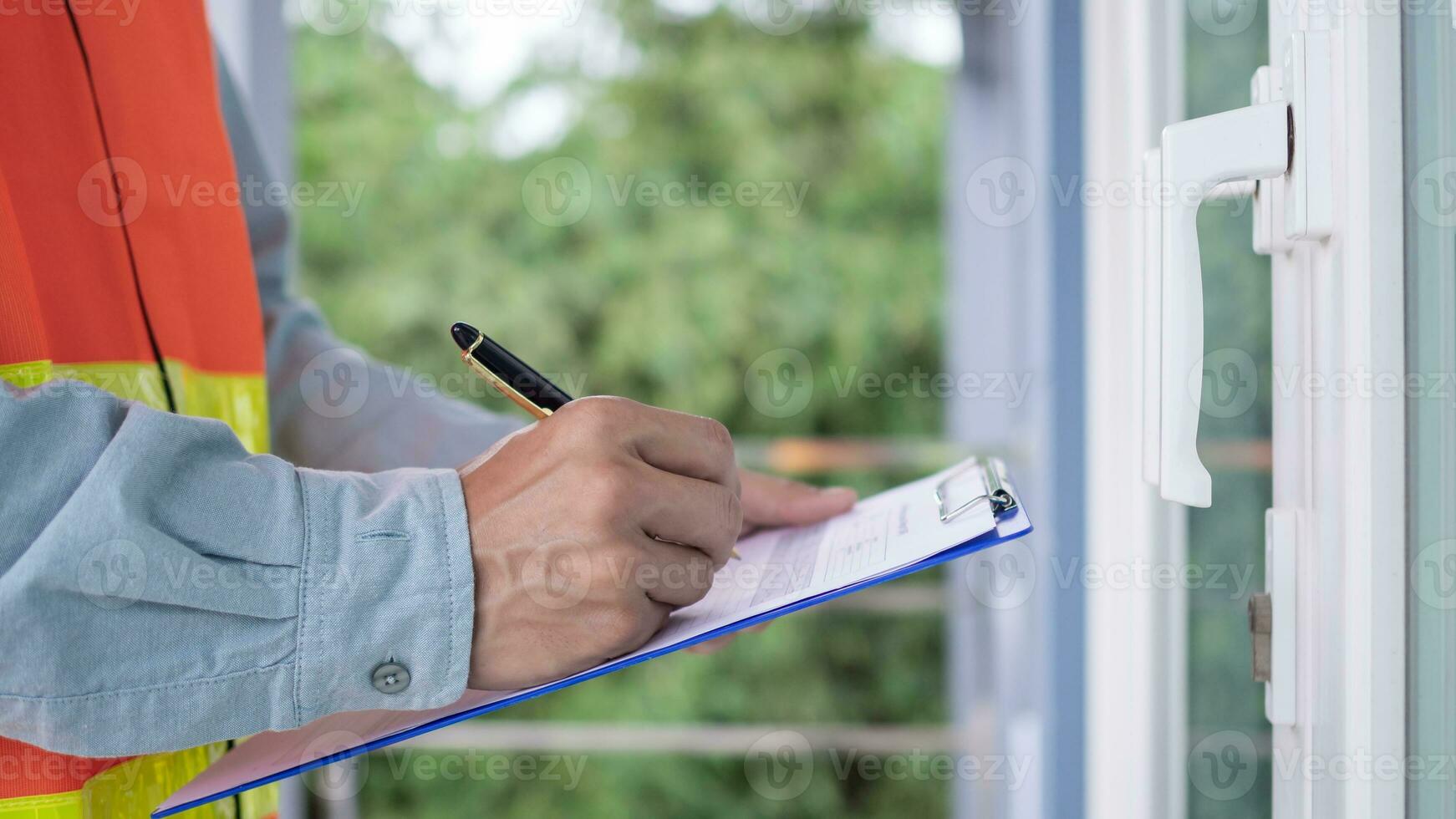 inspector or engineer is inspecting construction and quality assurance new house using a checklist. Engineers or architects or contactor work to build the house before handing it over to the homeowner photo