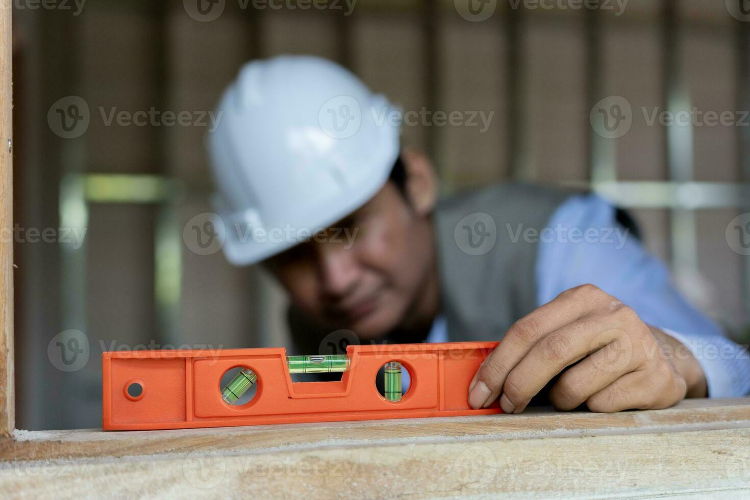 Contactor or engineer is inspecting construction and quality assurance new house using a level. Engineers or architects or contactor work to build the house before handing it over to the homeowner photo