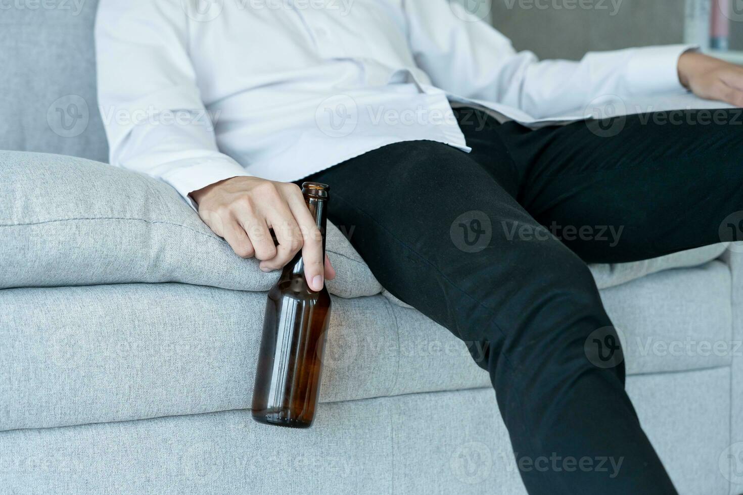 Depressed young business man addicted feeling bad drinking whiskey alone at home, stressed frustrated lonely drinking alcohol suffers from problematic liquor, alcoholism, life and family problems photo