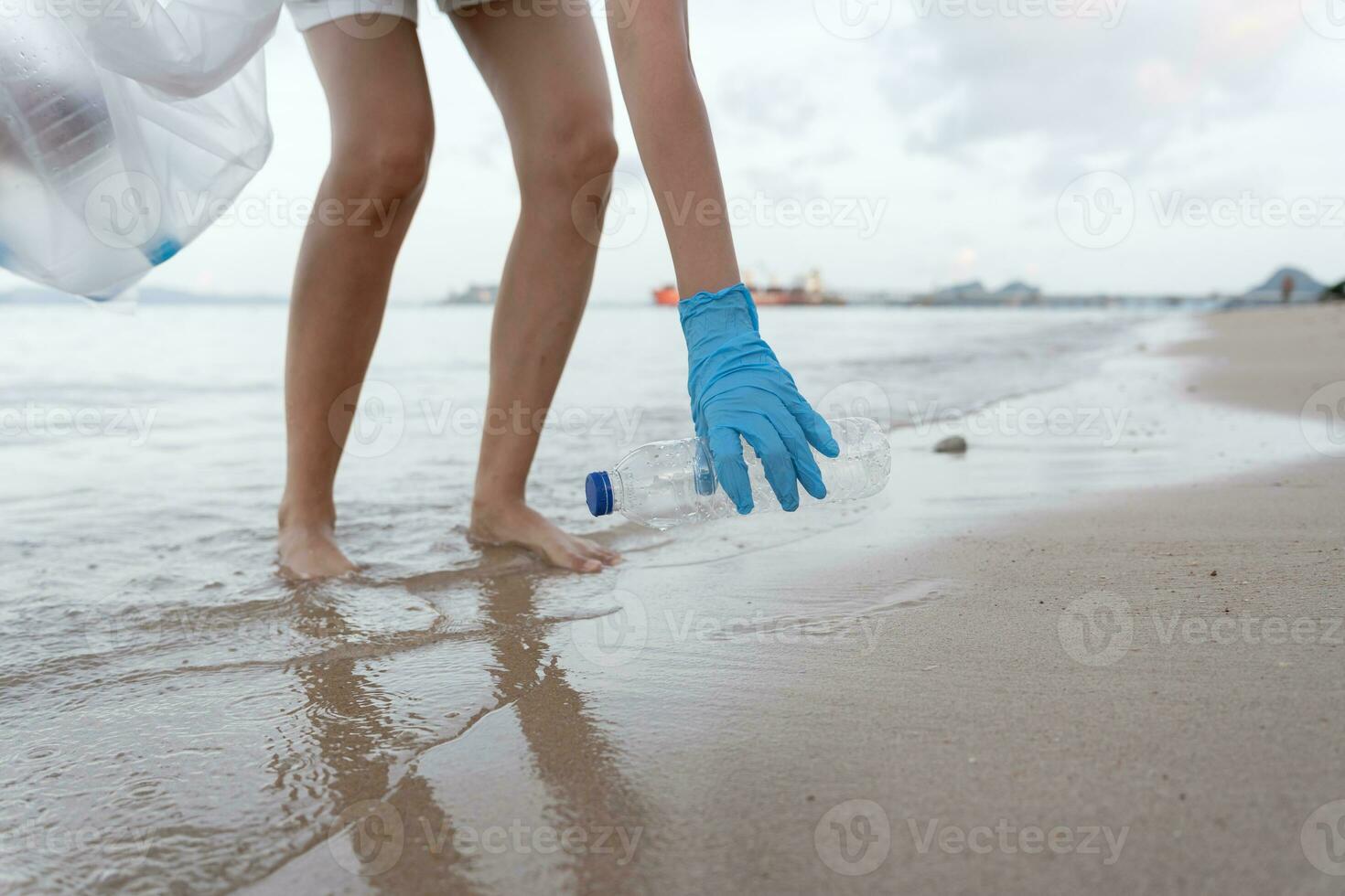 ahorrar agua. los voluntarios recogen basura en la playa y las botellas de plástico son difíciles de descomponer para evitar dañar la vida acuática. tierra, ambiente, planeta verde, reducir el calentamiento global, salvar el mundo foto