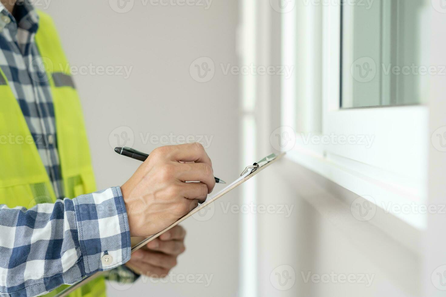 el inspector o ingeniero está inspeccionando la construcción y el aseguramiento de la calidad de la nueva casa usando una lista de verificación. ingenieros o arquitectos o contratistas trabajan para construir la casa antes de entregársela al propietario foto