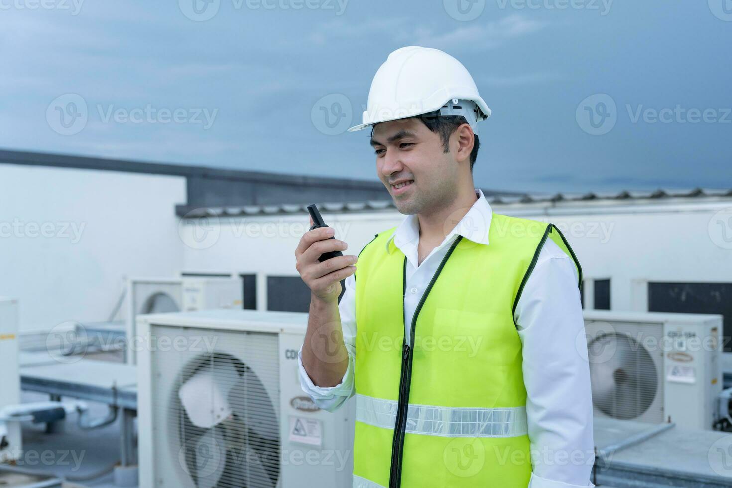 Asian maintenance engineer work on the roof of factory. contractor inspect compressor system and plans installation of air condition systems in construction. technology, walky talky, maintenance photo
