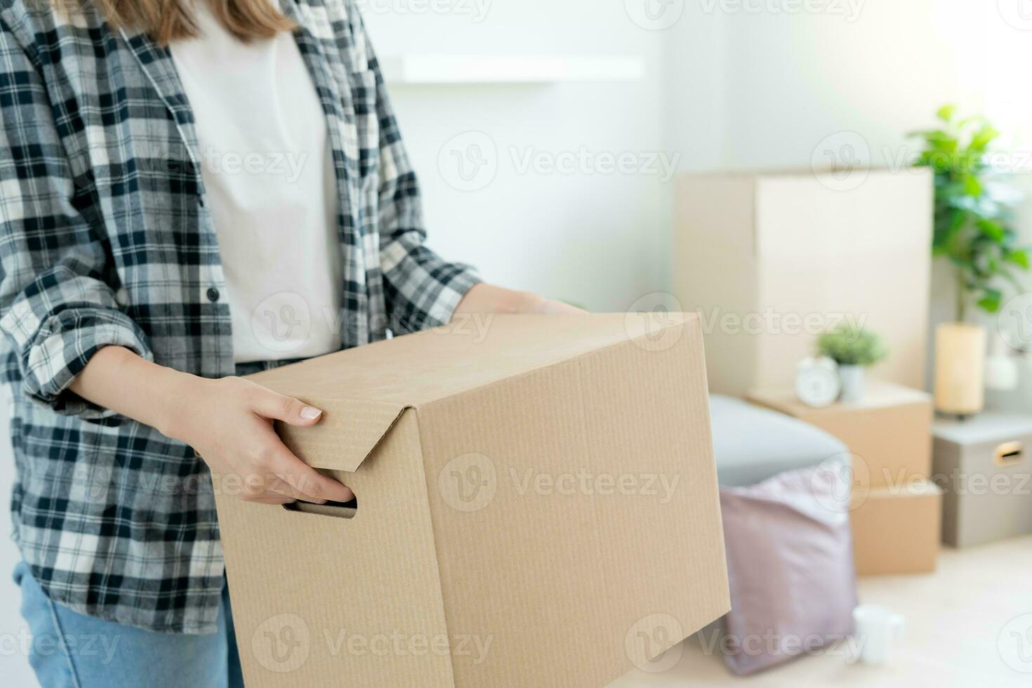 Moving house, relocation. Woman hand holding carton box on new apartment, inside the room was a cardboard box containing personal belongings and furniture. move in the house or condominium photo