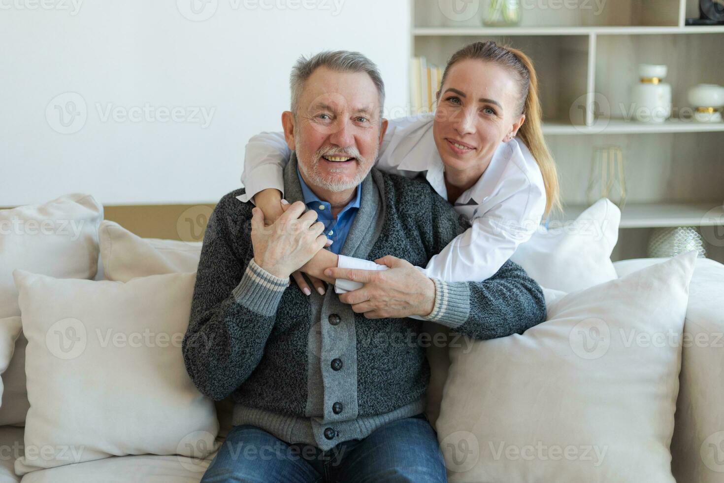 Happy family. Caring grown up daughter hugging loving older man father. Young woman embracing dad grandfather enjoying sweet bonding. Family generations together at home. Family moment love and care. photo