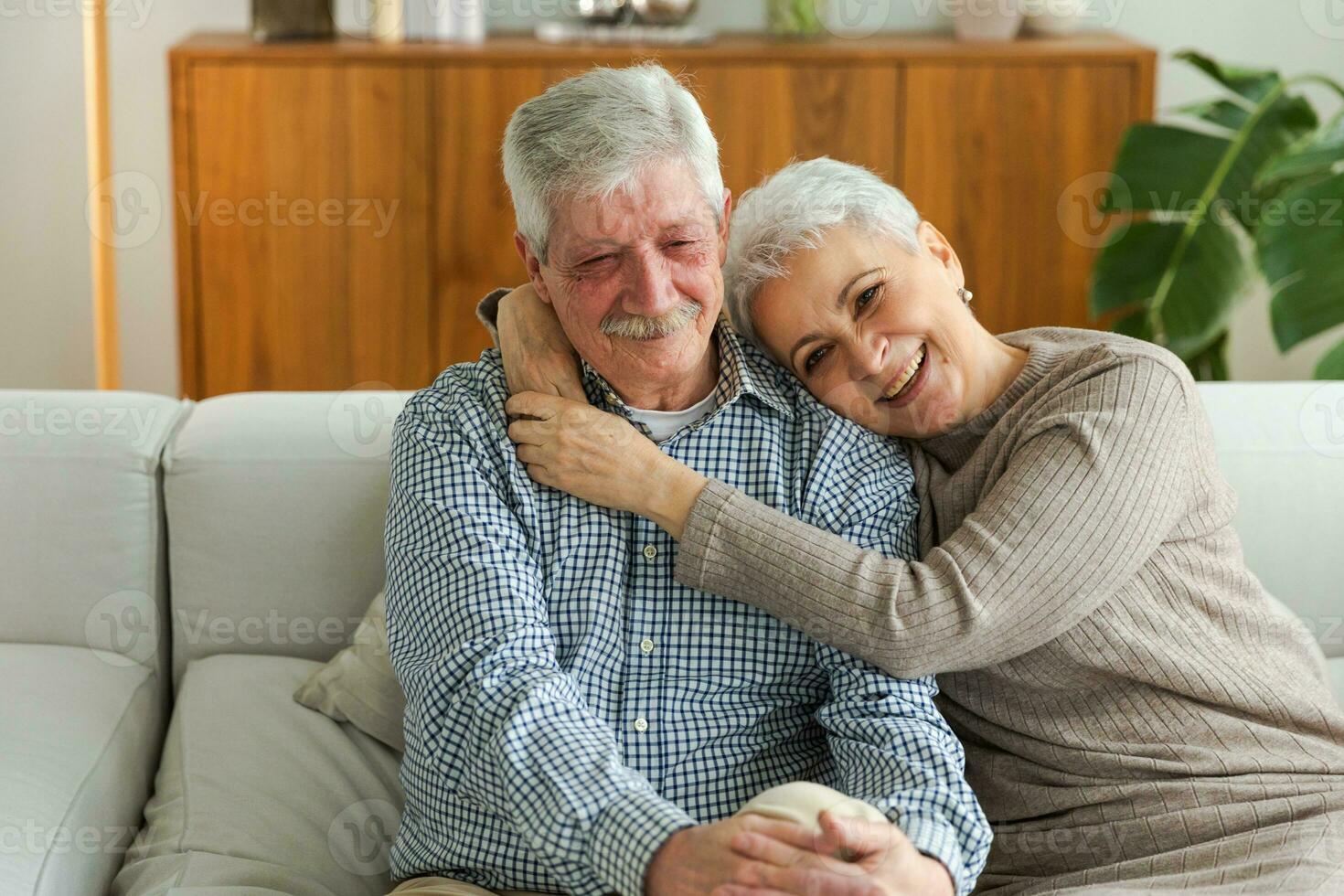 Senior adult mature couple hugging at home. Mid age old husband and wife embracing with tenderness love enjoying sweet bonding wellbeing. Grandmother grandfather together. Family moment love and care. photo