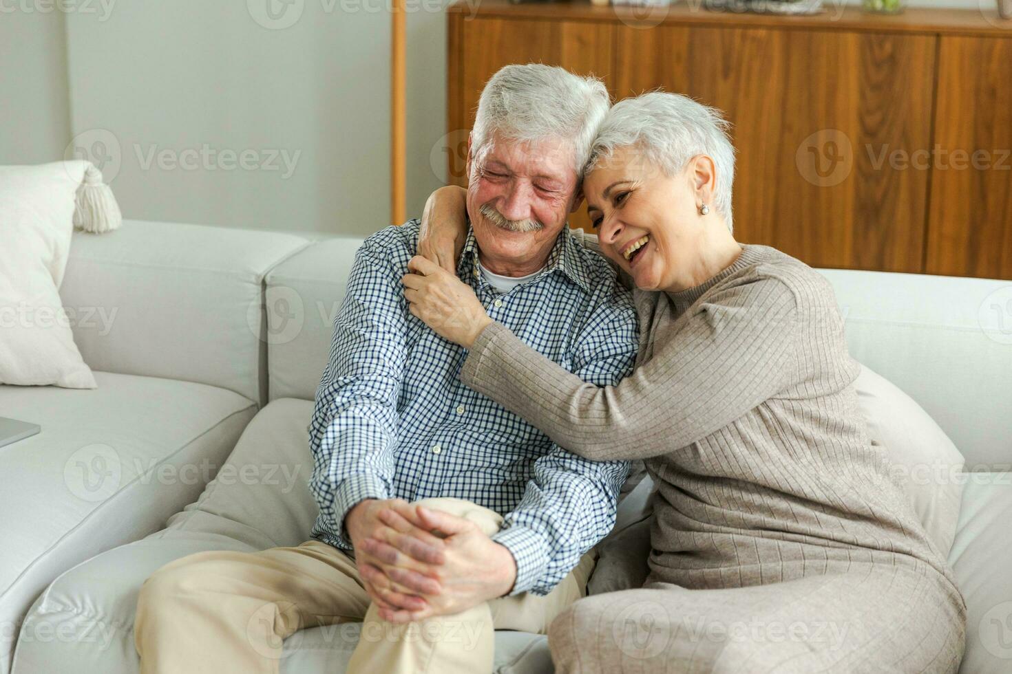 Senior adult mature couple hugging at home. Mid age old husband and wife embracing with tenderness love enjoying sweet bonding wellbeing. Grandmother grandfather together. Family moment love and care. photo