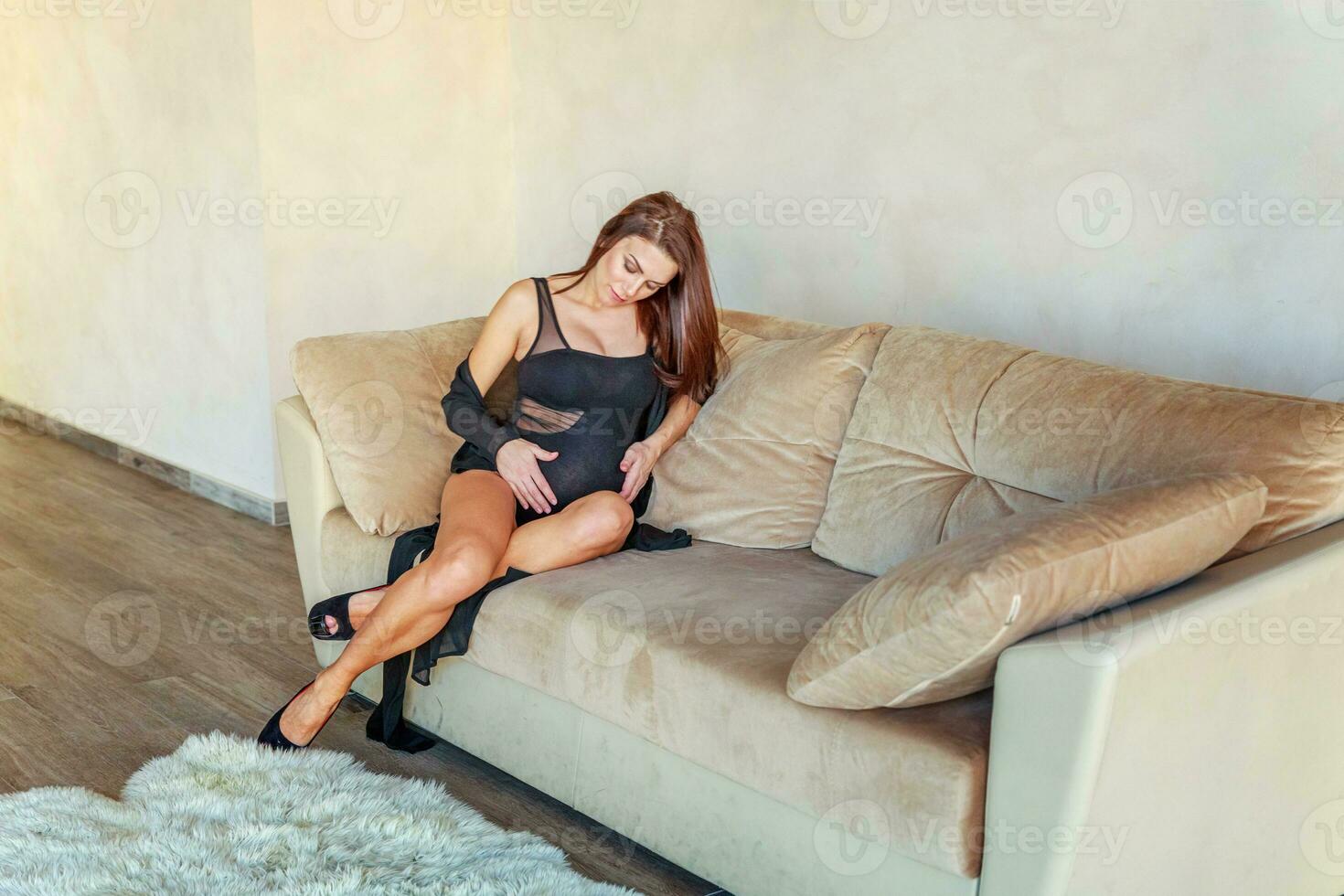 Pregnancy woman sitting on sofa at home photo