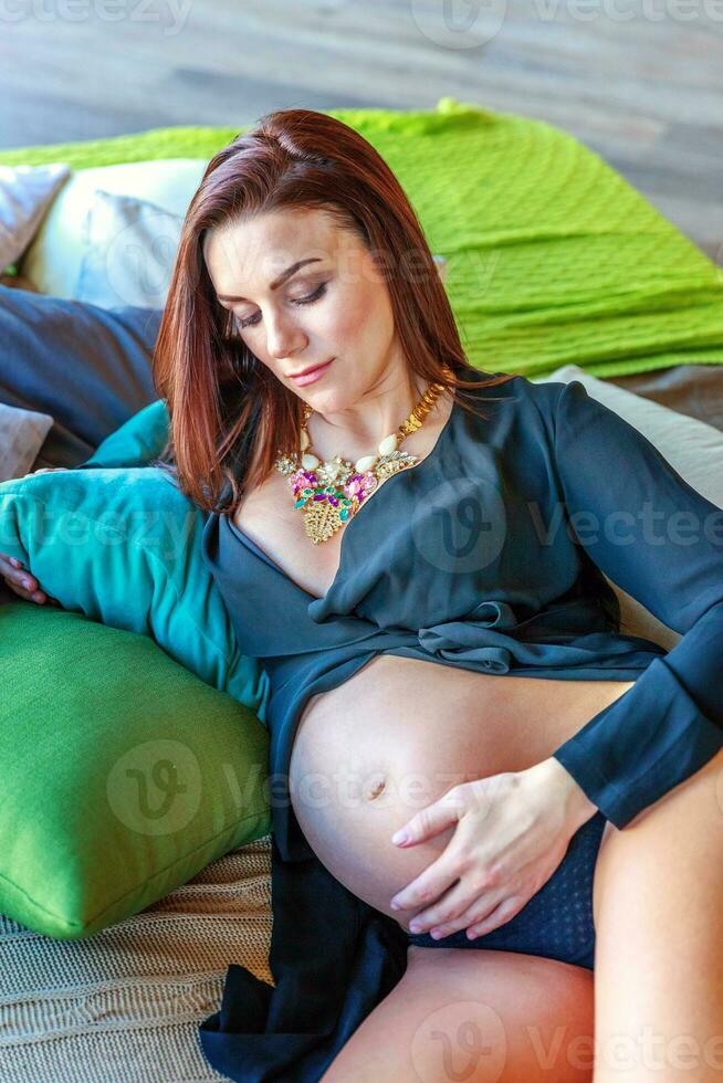 Pregnancy woman sitting on sofa at home photo