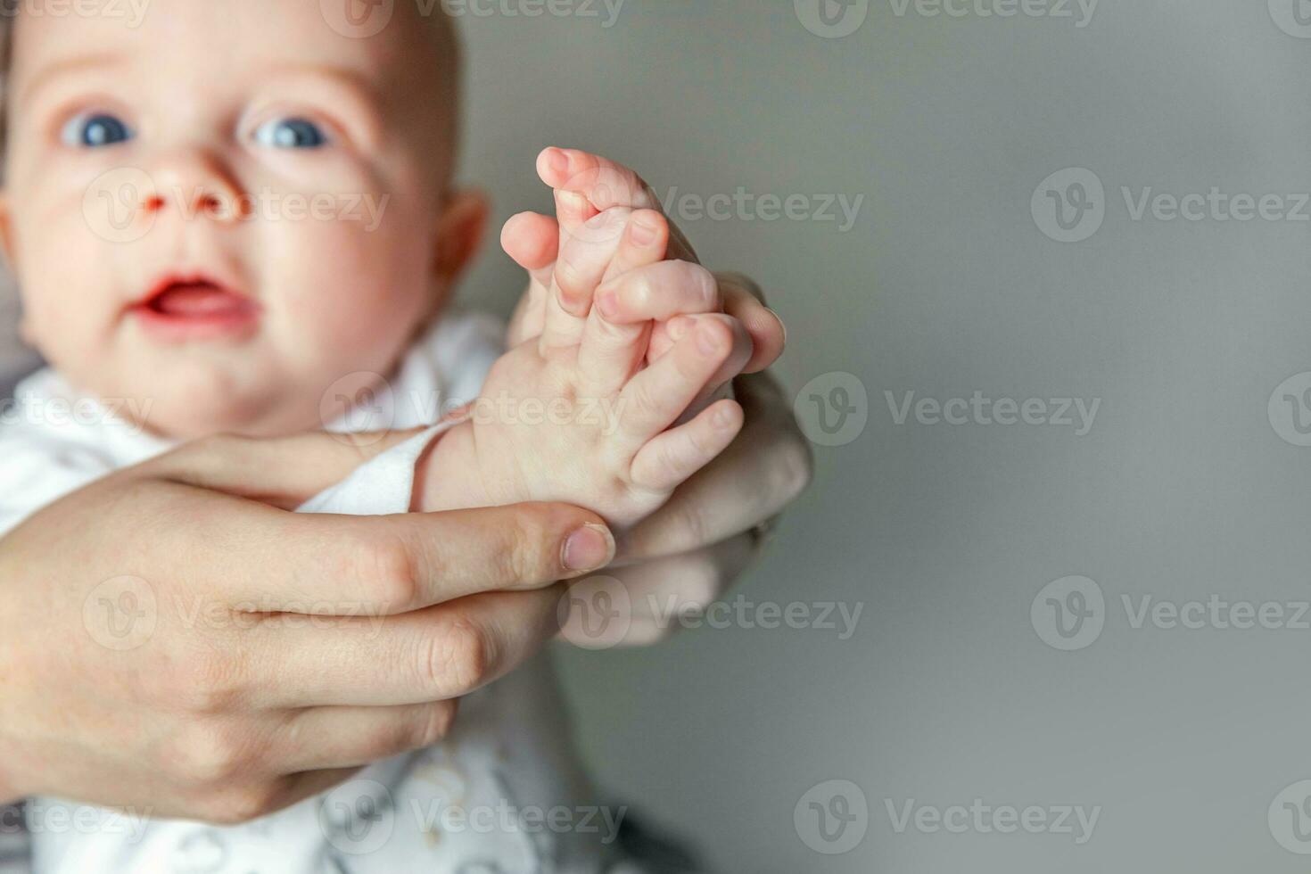 Young mother and newborn child clap their hands photo