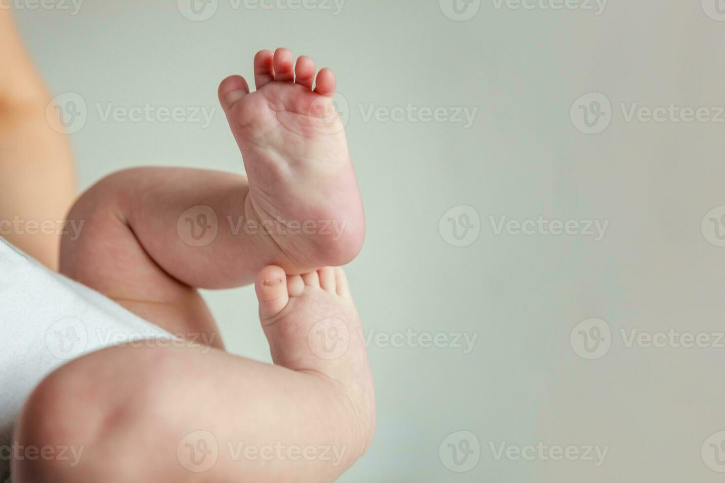 Tiny newborn infant male or female baby feet and toes on white background. photo