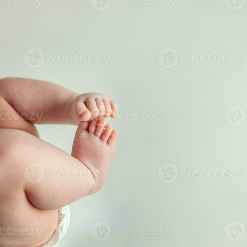 Tiny newborn infant male or female baby feet and toes on white background. photo