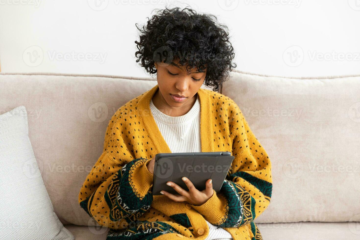 African american girl holding digital tablet touch screen typing scroll page at home. Woman with mobile tech device surfing internet using social media apps playing game. Study work shopping online. photo