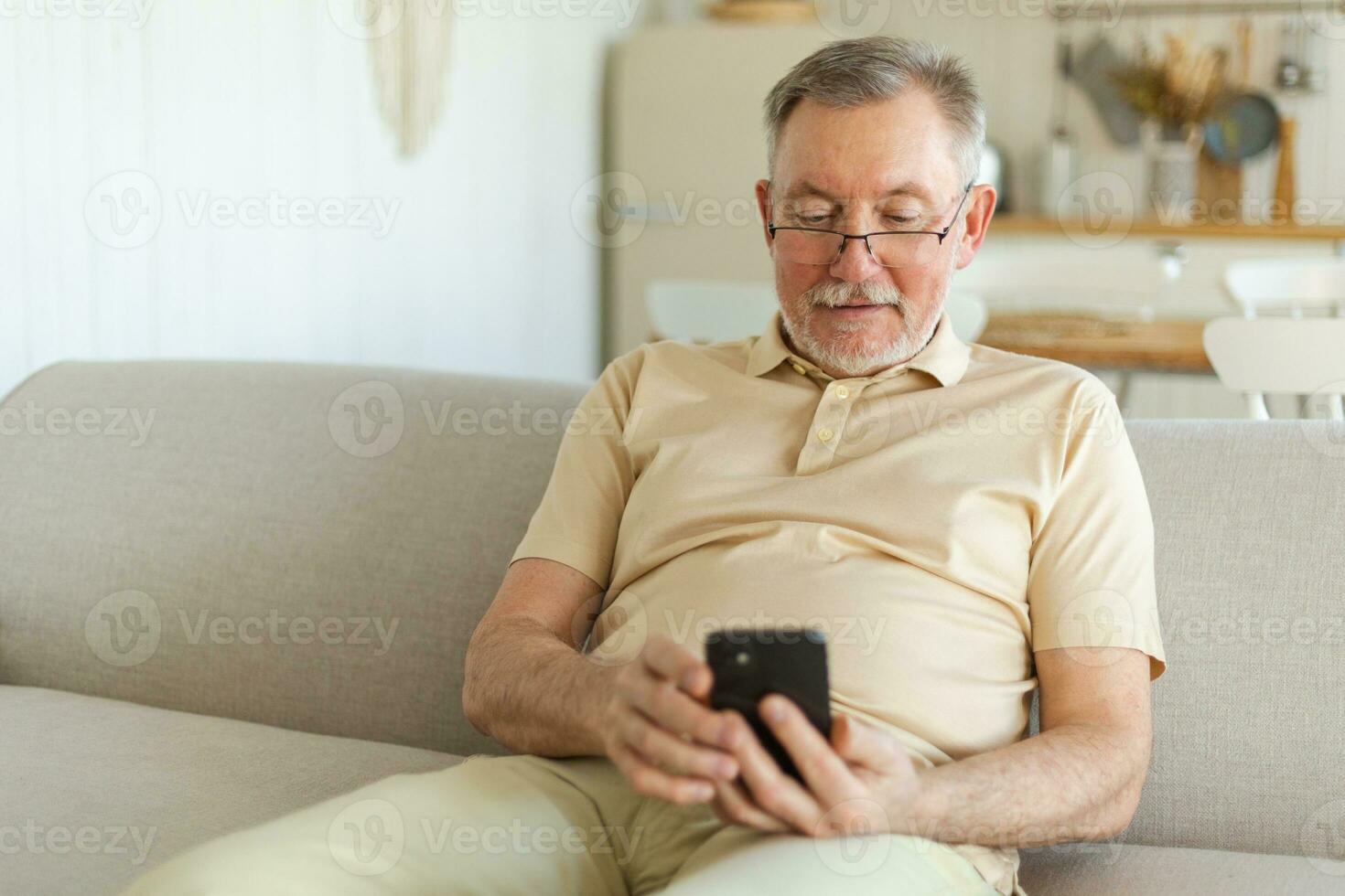 Happy middle aged senior man holding using smartphone touch screen typing scroll page. Stylish older mature beard grandfather with cell phone using internet social media apps at home. Shopping online. photo