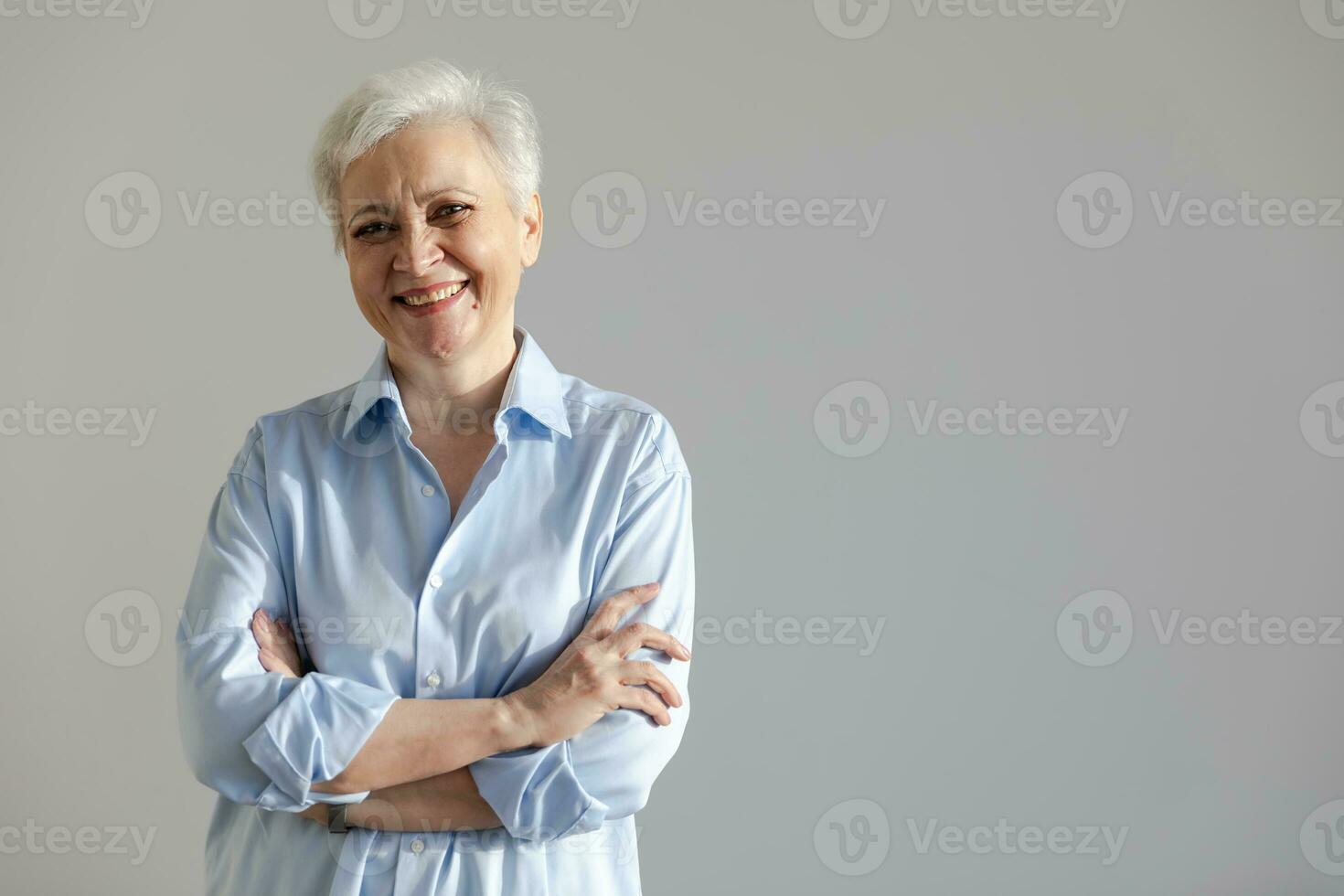 Confident stylish european middle aged senior woman. Older mature 60s lady smiling in white background. Happy attractive senior female looking camera close up face headshot portrait. Happy people. photo