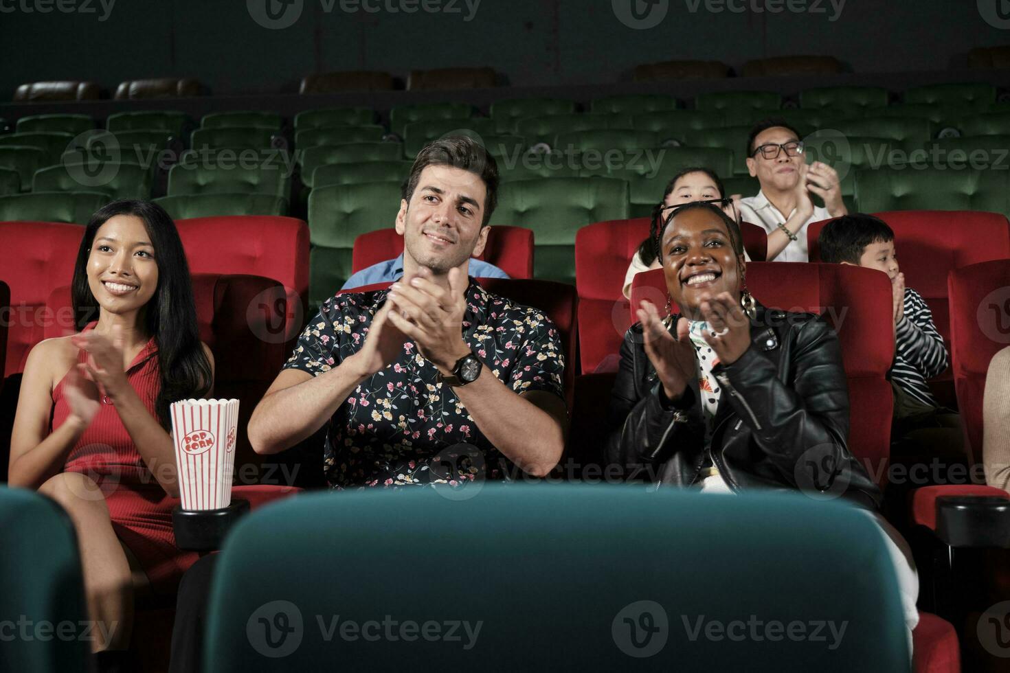 Various people in theater. Multiracial audiences, Black woman, and friends enjoy watching cinema and applauding together on movie shows, entertainment lifestyle with film, happy and cheerful smiles. photo