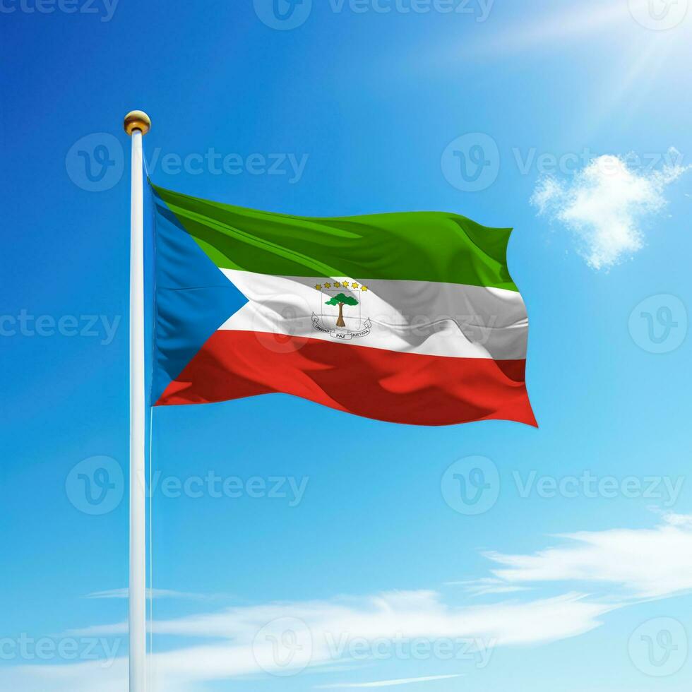 Waving flag of Equatorial Guinea on flagpole with sky background. photo