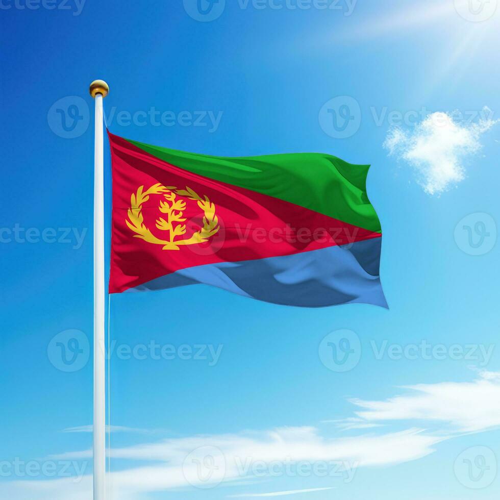 Waving flag of Eritrea on flagpole with sky background. photo