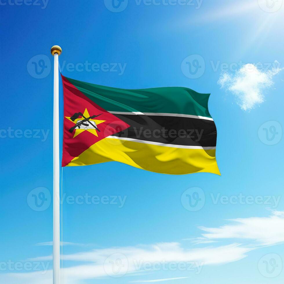 ondulación bandera de Mozambique en asta de bandera con cielo antecedentes. foto
