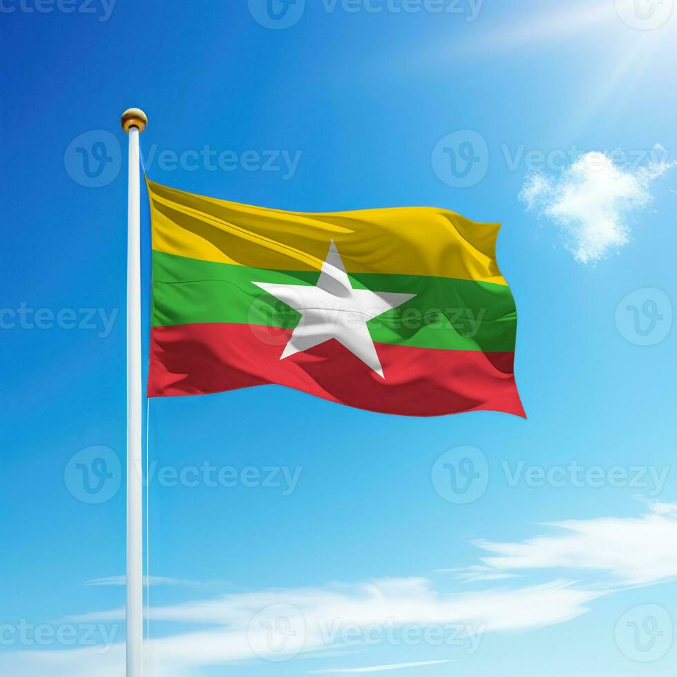 Waving flag of Myanmar on flagpole with sky background. photo