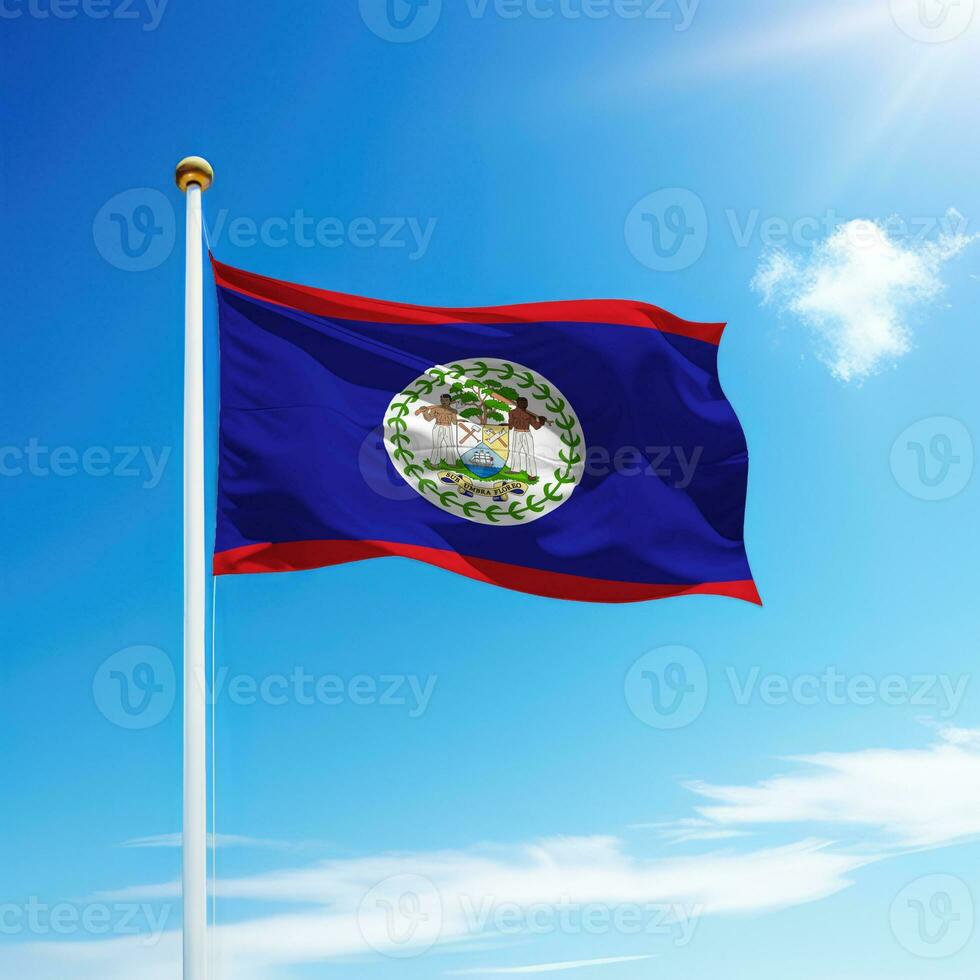 Waving flag of Belize on flagpole with sky background. photo