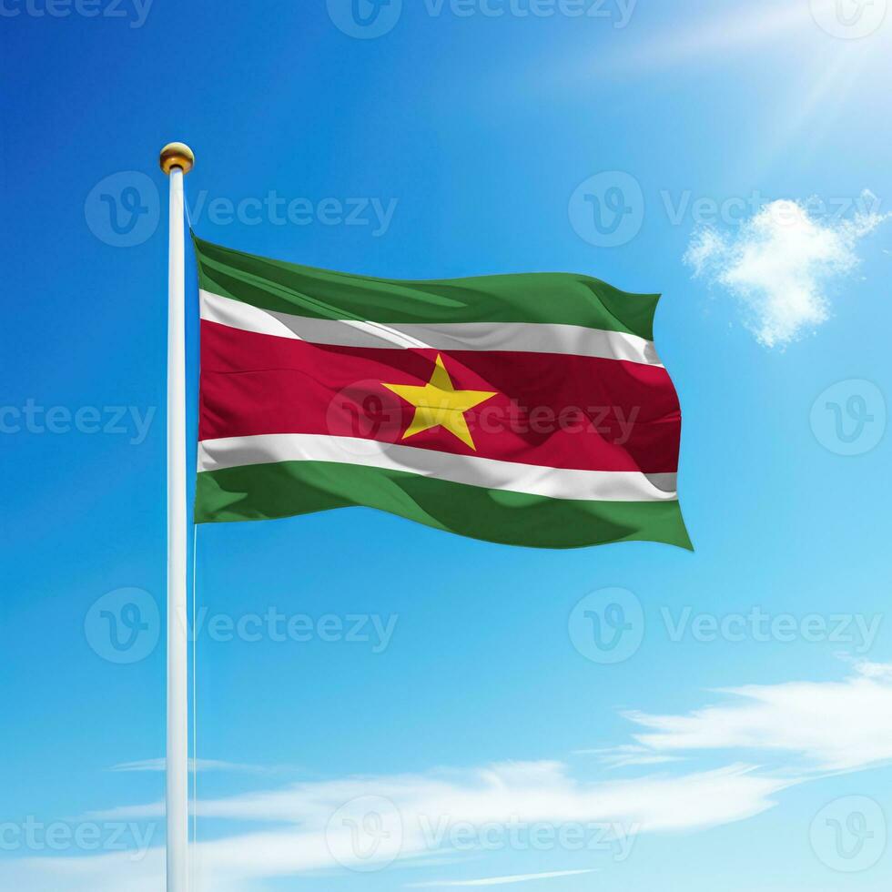 Waving flag of Suriname on flagpole with sky background. photo