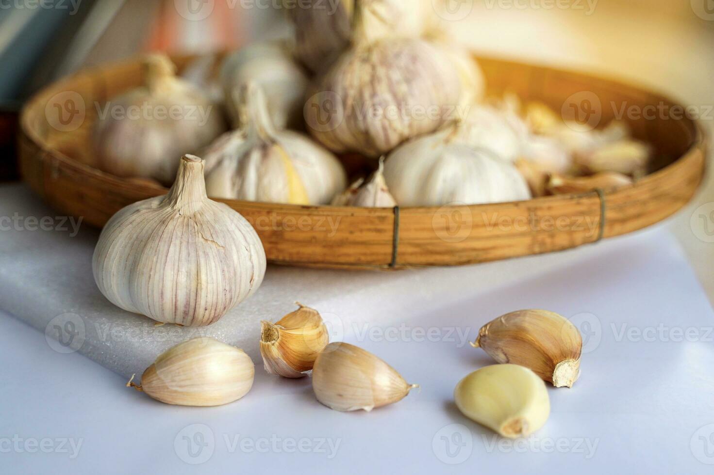 Garlic in a bamboo basket on a white background It is a medicinal plant in Thai kitchens used as an ingredient in food. It has a pungent odor and a spicy taste. It can be eaten both fresh and cooked. photo