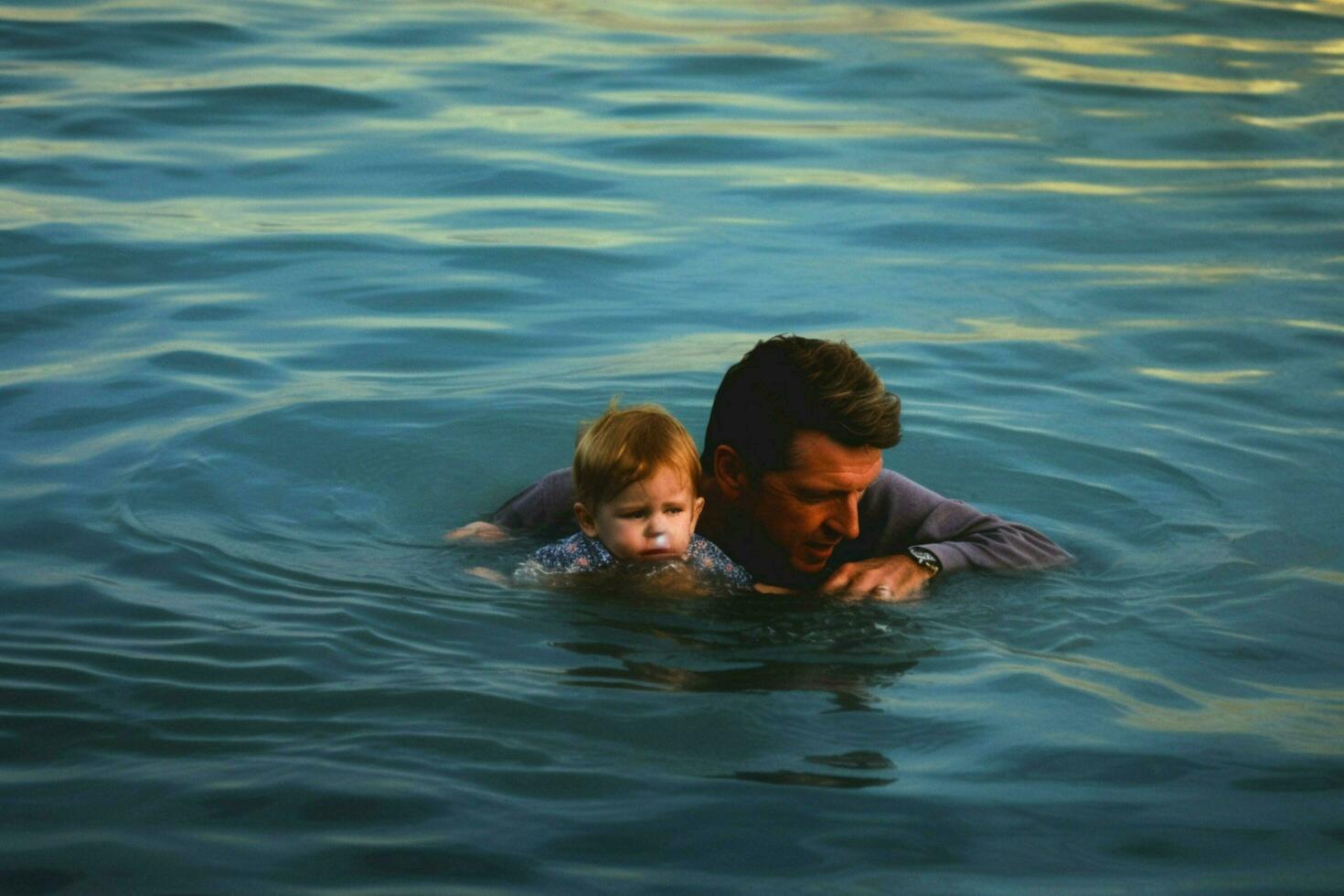 A father teaching his child to swim photo