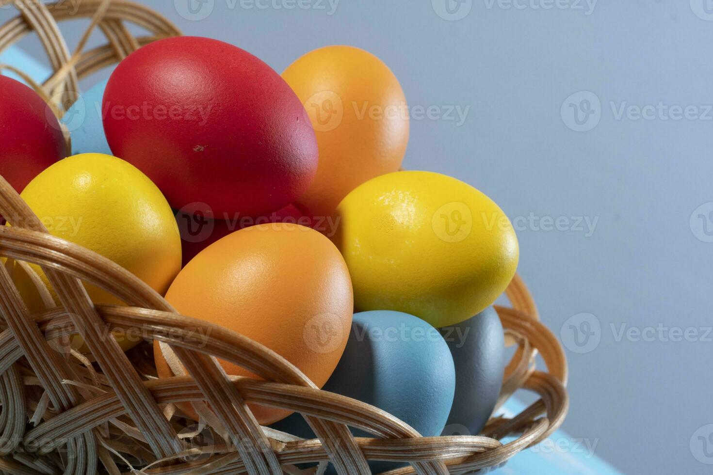 easter basket with straw and colored eggs photo