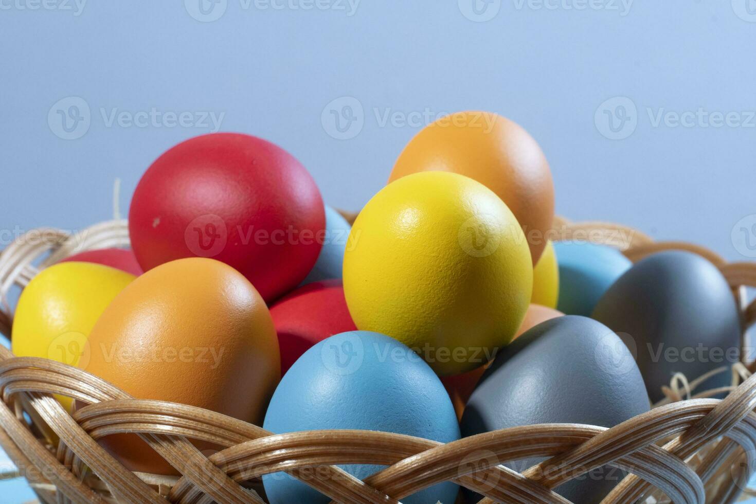 easter basket with straw and colored eggs photo