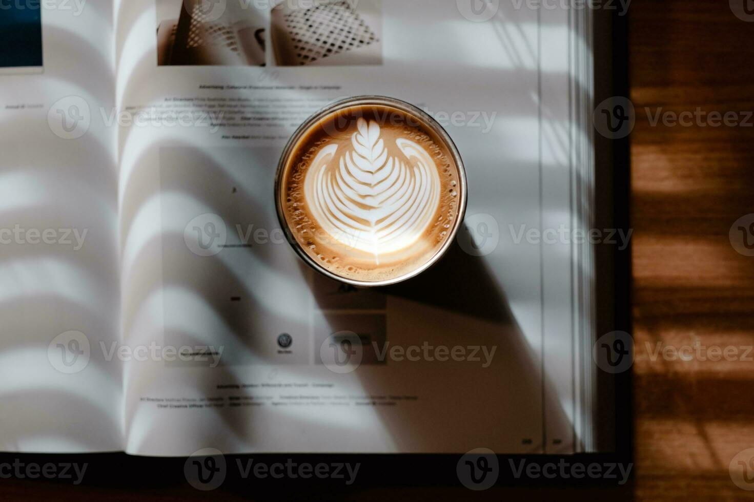 A book and coffee latte art in a beautiful sunlight coming through blinds photo